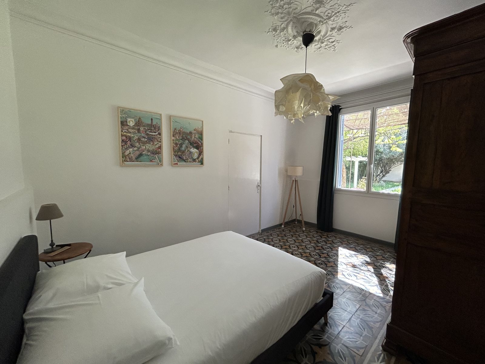 Chambre avec vue jardin, carreaux de ciment et armoire en bois